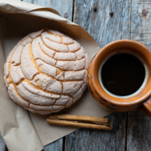 This is an image showing a cup of café paired with one of our many traditional Mexican pastries, a concha